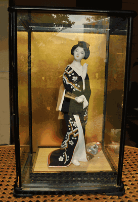 geisha doll in glass case